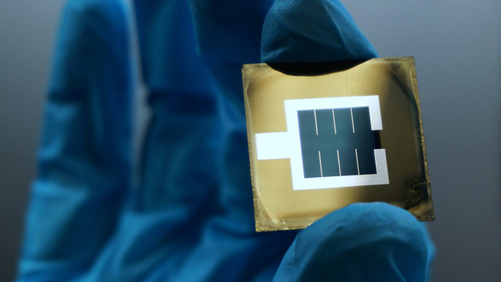 Tandemsolarzelle: Zu sehen ist die aktive bläuliche Fläche in der Mitte des Wafers, die von der metallischen, silbrigen Elektrode eingeschlossen wird.