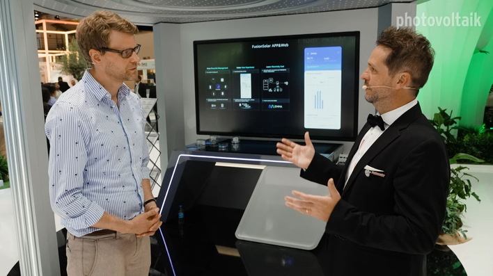 Niels Hendrik Petersen von der photovoltaik-Redaktion (links) informiert sich am Messestand von Huawei.