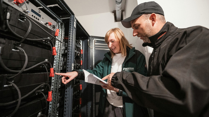 In der Energiezentrale begutachten Melanie Kühl (Naturstrom) und Gordon Grundorf (S2 Gebäudetechnik) die Batteriespeicher.