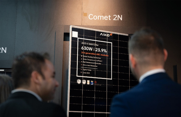Personen betrachten eine Anzeige für das Solarpanel von AIKO, Modell Comet 2N, mit hervorgehobenen Spezifikationen. - © Foto: Aiko