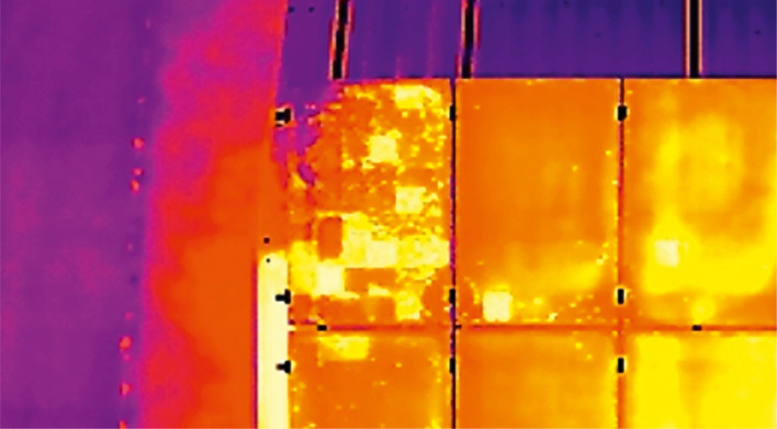 Wärmebild, das die unterschiedlichen Wärmegrade auf einem Solarpanel zeigt, wobei helles Orange und Gelb Bereiche mit hoher Hitze anzeigen. - © Foto: PVision