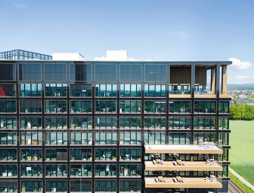 Alle Flächen zwischen den Fenstern des Bürogebäudes in Eschborn wurden mit Solarmodulen verkleidet. 26 verschiedene Modul­größen wurden verbaut, damit die Fassade gleichmäßig wirkt.