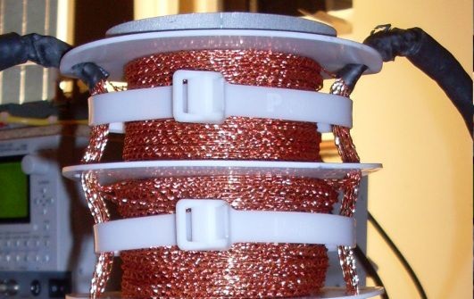 Das Netz um die eigentliche Kupferleitung induziert das Magnetfeld. Dadurch sinkt der Widerstand im Leiter und die Elektronen kommen schneller durch.